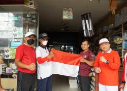 Tampak sekda hamka membagikan bendera merah putih