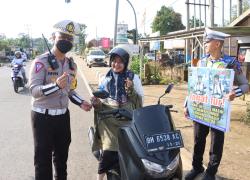 Kasatlantas memberikan bunga kepada pengendara motor(Hadi su/foto)